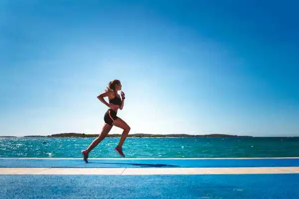 Woman running showing strong leg muscle Virginia Water